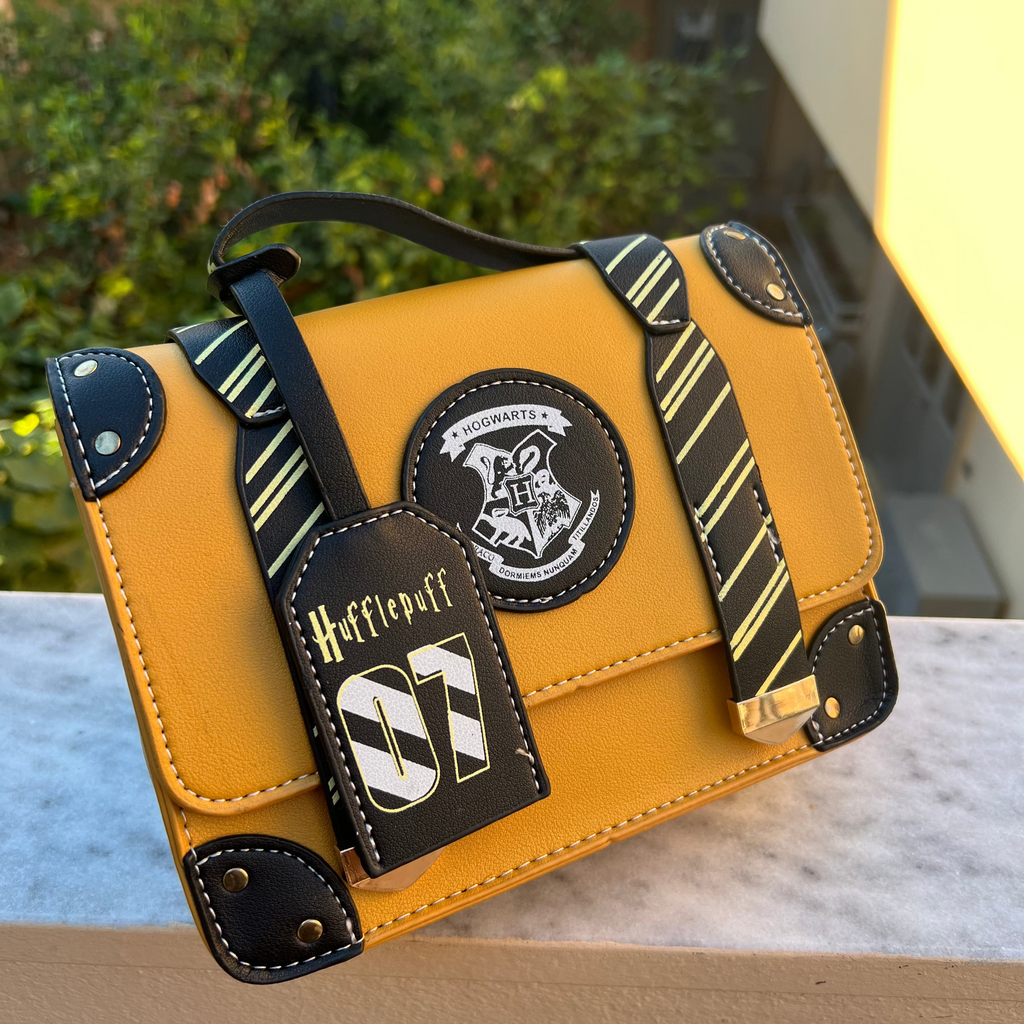 Yellow bag with black accents and patches on a surface outdoors