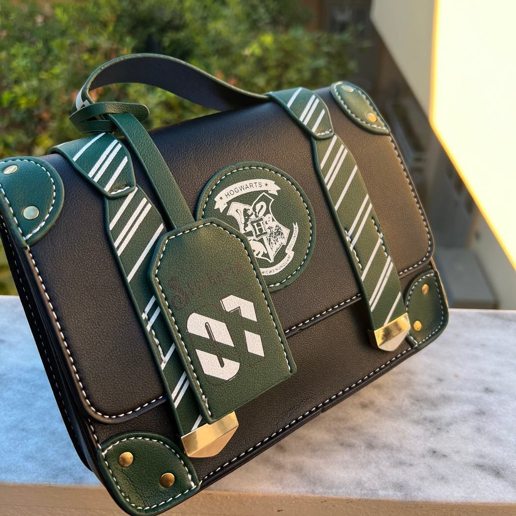 Green and black handbag with a logo on a surface outdoors